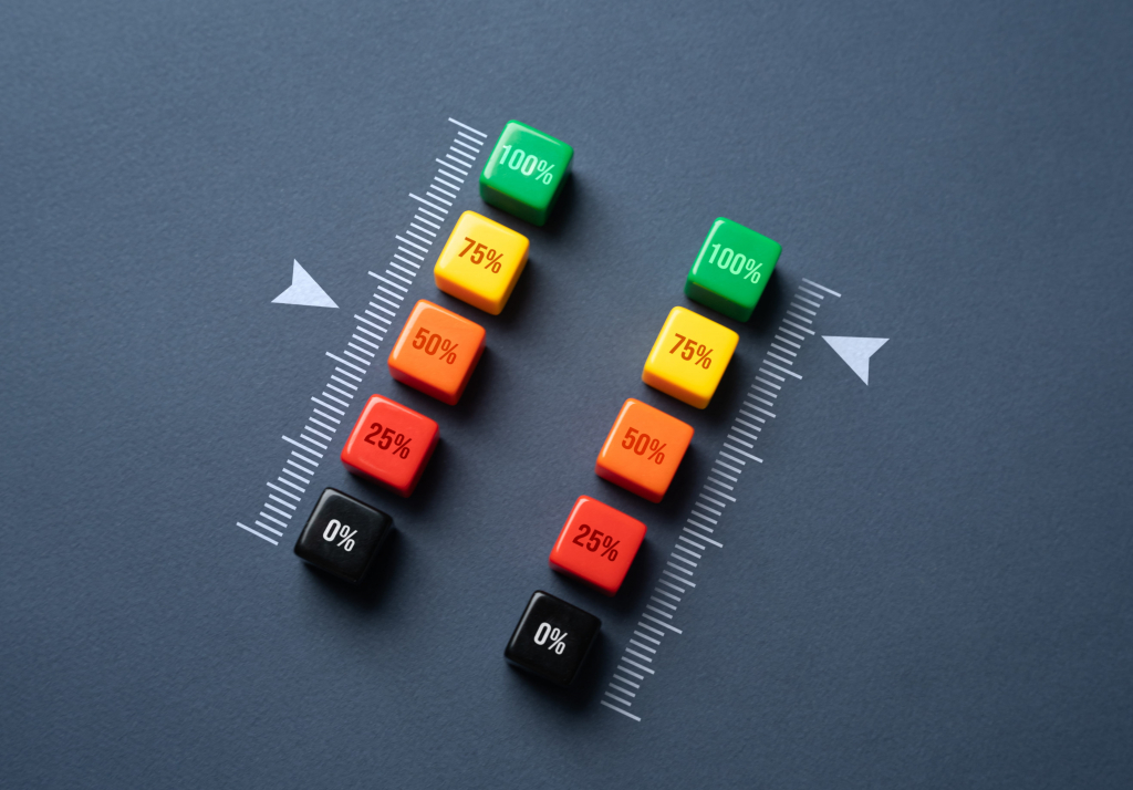 Eine Gruppe von bunten Würfeln mit Zahlen übereinander, daneben sind Skalen mit Pfeilen. auf der linken Siete ist es im grünen auf der rechten Seite im roten Bereich.